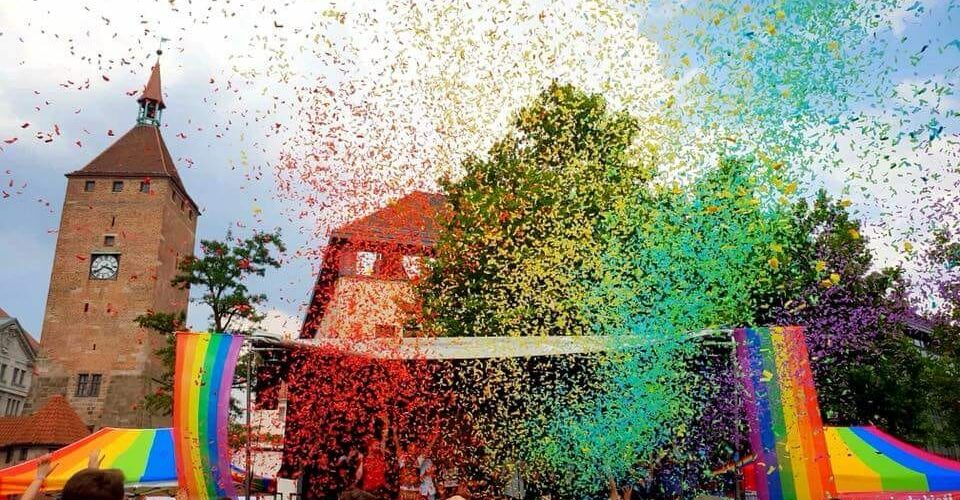 2018 Regenbogenfahnen und Confetti vor Kirchturm